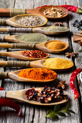 Spices for cooking with kitchen accessories on an old background