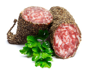 Dried organic salami sausage covered with pepper on white background