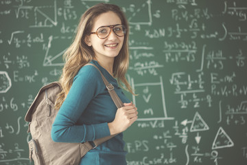 Female student with backpack on chalkboard background