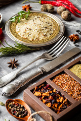 Spices for cooking with kitchen accessories on an old background