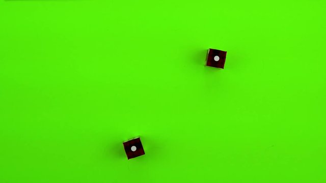 Red casino dice being rolled and settling on craps (double one) on a green screen. Multiple rolls
