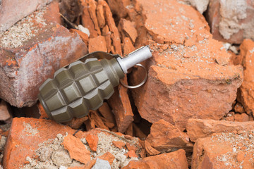 Hand grenade lying on a brick wall