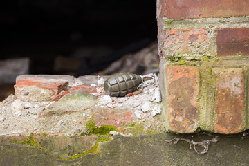 Hand grenade lying on a brick wall
