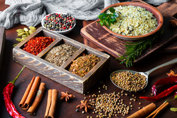 Spices for cooking with kitchen accessories on an old background