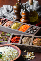 Spices for cooking with kitchen accessories on an old background