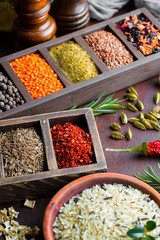 Spices for cooking with kitchen accessories on an old background