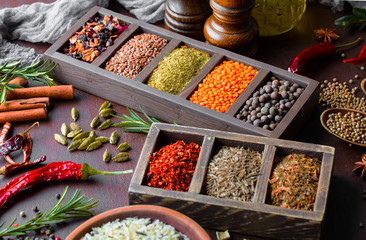 Spices for cooking with kitchen accessories on an old background