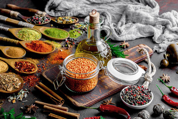 Spices for cooking with kitchen accessories on an old background