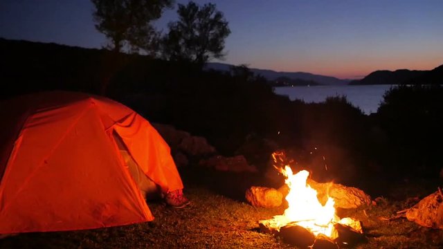 camping with tent and fire in wilderness