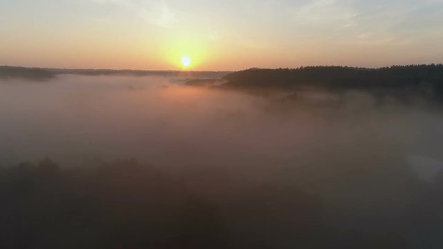 Sunrise Drone footage above the fog and river in fall