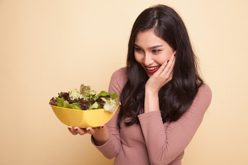 Healthy Asian woman show OK with salad.