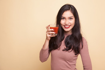 Asian woman with a clock drink orange juice.