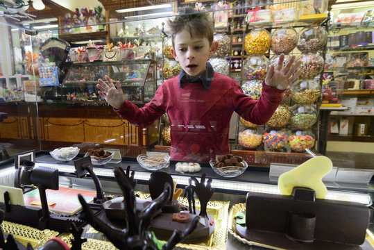 Child fascinated in the shop window of chocolate shop-horizontal