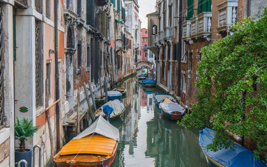 Fototapeta na wymiar Small pretty canal with boats in Venice