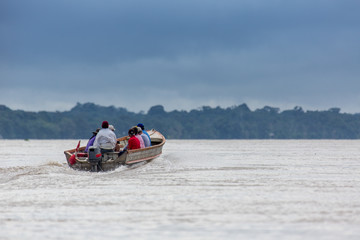 Fototapeta na wymiar A Small Wooden Boat Motoring on the Amazon River in Peru