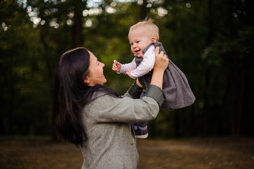 Obraz premium Portrait of brunette mother playing with a cute baby daughter