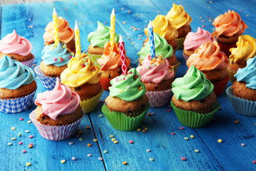Tasty cupcakes on wooden background. Birthday cupcake in rainbow colors
