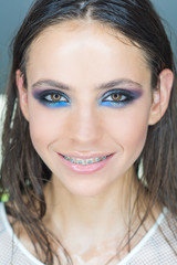 Naklejka premium Woman with braces on teeth. Happy girl smile with dental braces. Woman smiling with bright eye makeup and long hair, beauty. Dental health concept. Beauty model with glamour look, make up