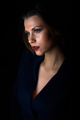 Fototapeta premium Sexy young blonde with red lips on a black background