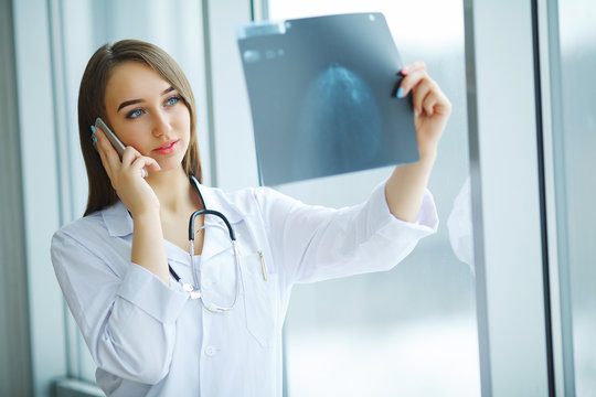 Young female doctor looking at x-ray image