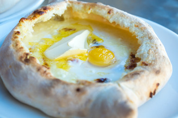 Adjarian khachapuri with eggs and butter on the table