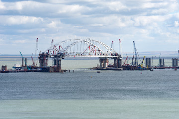 the bridge is being built in the Kerch Strait and the sea and a cloudy sky