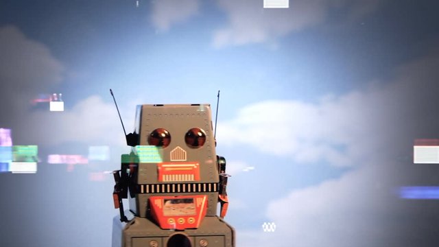 Many digital tv glitches over a scene: a tin toy robot moving in front of an almost cloud-free clean sky.
