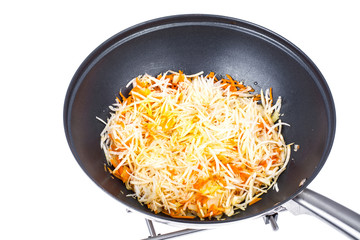 Chopped carrots and celery root in frying pan