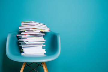 A stack of books in the interior in a minimalist style. Monocolor. The concept of reading, education, buying books. Copy space