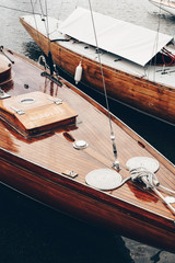 Mooie klassieke houten boten aangemeerd in de zeehaven op een nog donker water. Glanzende laklaag van het dek en smalle bronzen houten panelen. Helsinki, Finland
