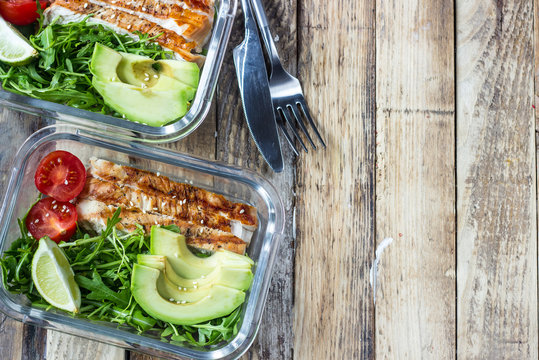 Healthy meal prep containers with rukola, turkey grill, tomatoes and avocado