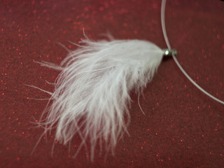  soft white feather jewelry - red background