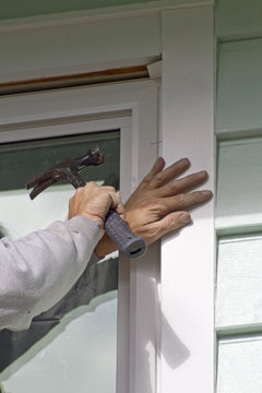 Man Using Hammer to Install a Window