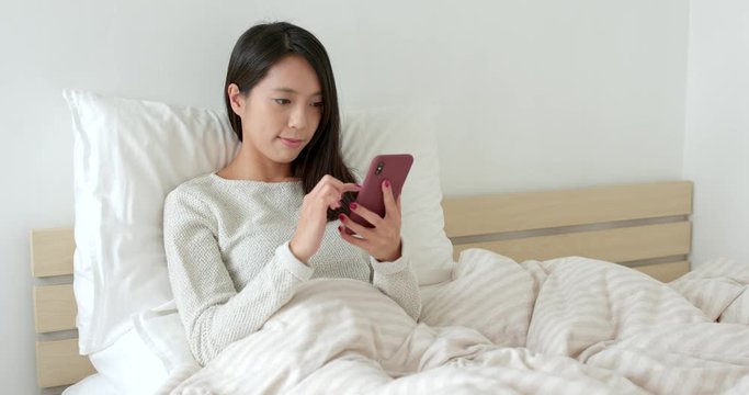 Woman use of mobile phone on bed