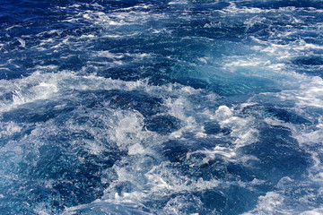 Fototapeta na wymiar Turbulence made by the foam of sea water from a high-speed yacht on the surface of the sea. Image for background, wallpaper or desktop, abstract texture