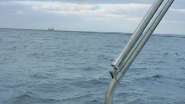 View of large ship from cockpit of yacht siling in ocean