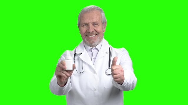 Portait of old man commend pills. Take this pills. Green screen hromakey background for keying.