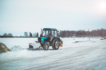 Tractor clears the embankment from snow