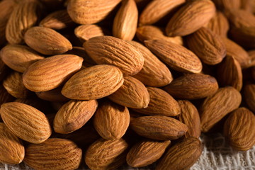 pile of almond nuts on wooden table.