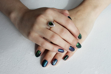 hands of a young girl with green manicure, which shows a sign of biological danger biohazard. On...