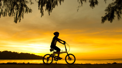 Silhouette of cyclist at sunset or sunrise near ocean