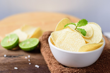 Potato chips in a bowl on brown fabric