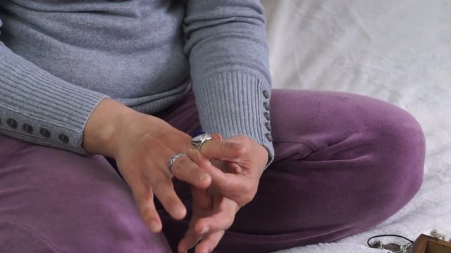 closeup of woman hands putting ring on her finger