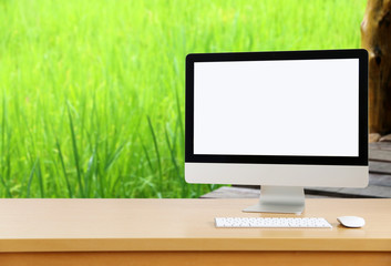 Computer screen on the desk green nature background