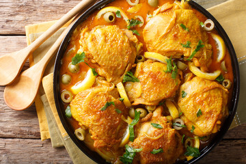 Moroccan food: tajine chicken  with salted lemons, onions and olives close-up. horizontal top view