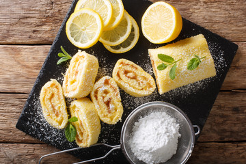 English lemon sweet roll cake with a fruity curd close-up. Horizontal top view from above