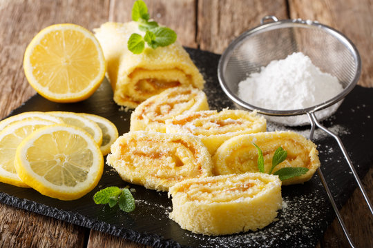 Traditional lemon roll with fruit curd, with mint and sugar powder close-up. horizontal