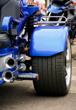 rear side of a blue motorcycle. lovely detail shot of lights and shiny exhaust pipes