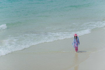 woman walks alone on a deserted beach
