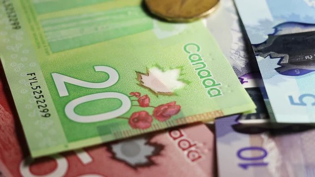 Close Up Of Canadian Money With Coins Falling On Top Of Paper Money. Multicolored Bank Notes In A Pile.